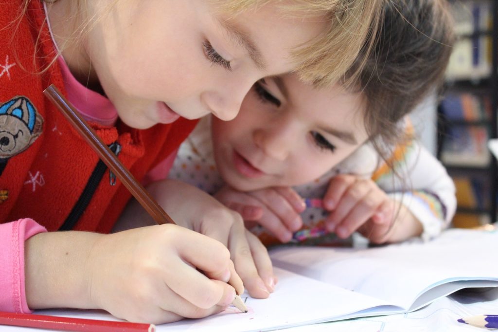 Niños escribiendo en un cuaderno. Educación